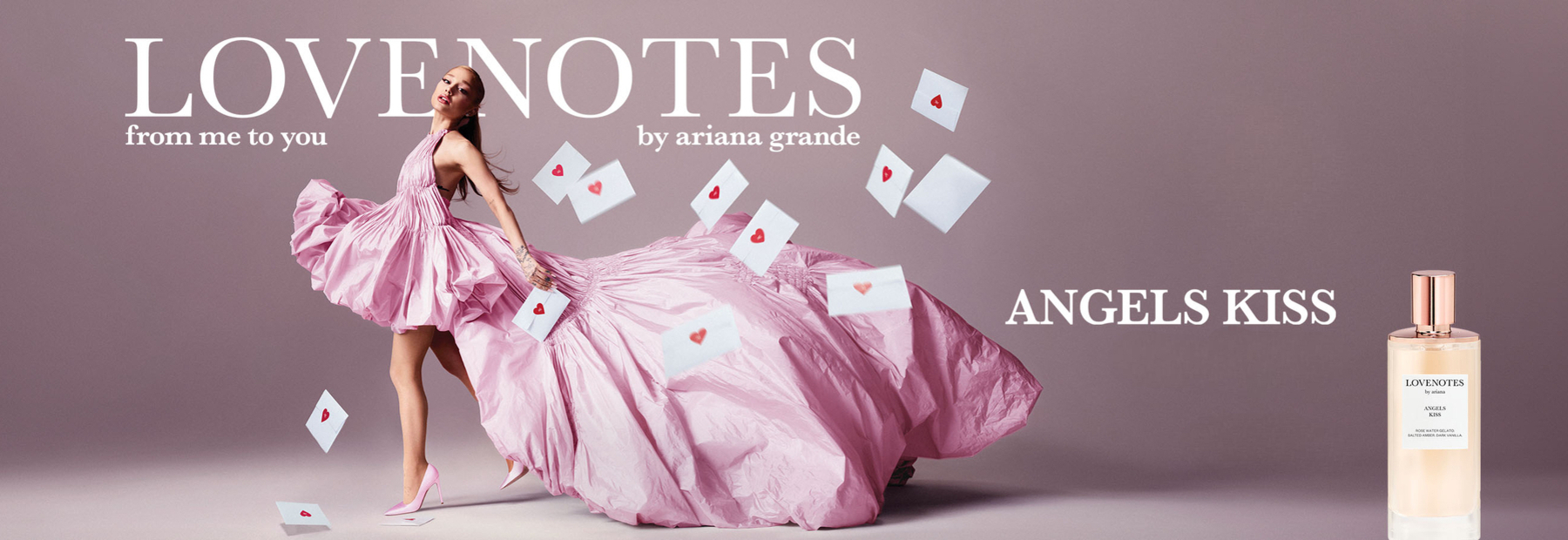 Ariana Grande rozā kleitā “LOVENOTES: Angels Kiss” smaržu reklāmā, apkārt lido mīlestības vēstules ar sirsniņām, labajā pusē smaržu pudele.