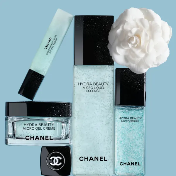 CHANEL Hydra Beauty produkti – krēms, serums un esence ar kamēlijas ziedu uz zilas fona.