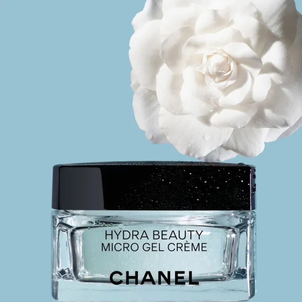 CHANEL Hydra Beauty Micro Gel Crème stikla krēms ar melnu vāciņu un baltu kamēlijas ziedu uz zilas fona.