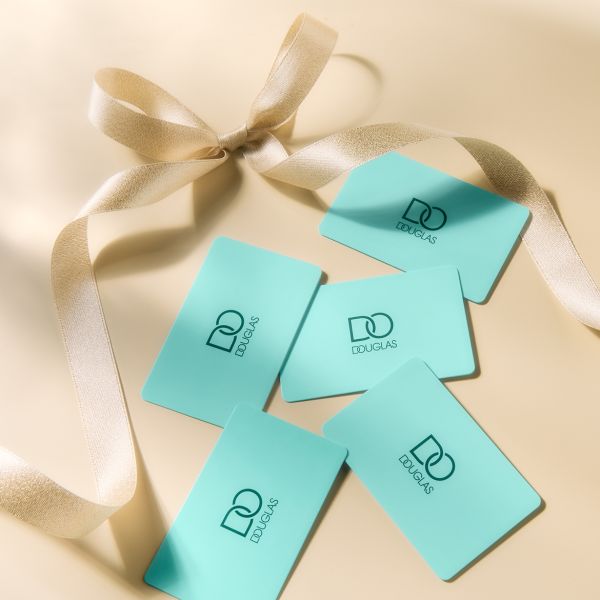 Zilas Douglas dāvanu kartes ar zelta lentīti uz bēša fona - lieliska dāvana jebkuram gadījumam