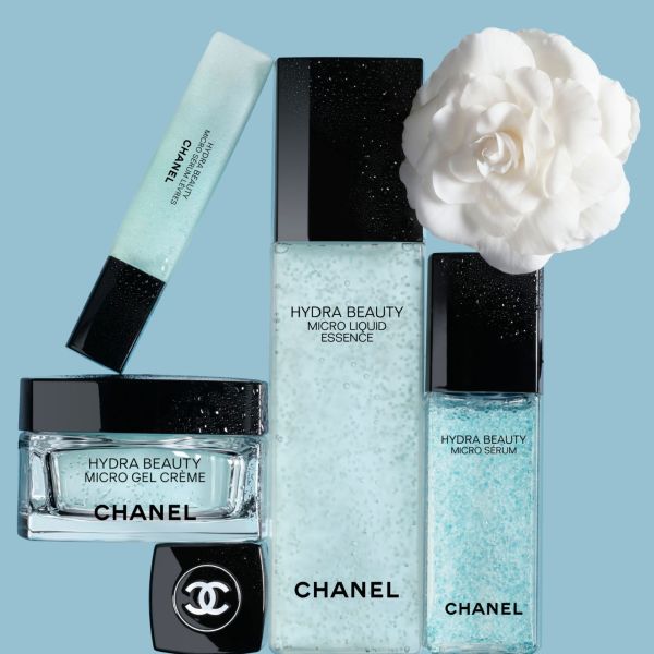 CHANEL Hydra Beauty produkti – krēms, serums un esence ar kamēlijas ziedu uz zilas fona.