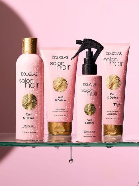 Komplektā ietilpst četras rozā pudeles ar zelta vāciņiem, Douglas Salon Hair Curl & Define, cirtainiem matiem, ieskaitot šampūnu, kondicionieri, laku un līdzekli.